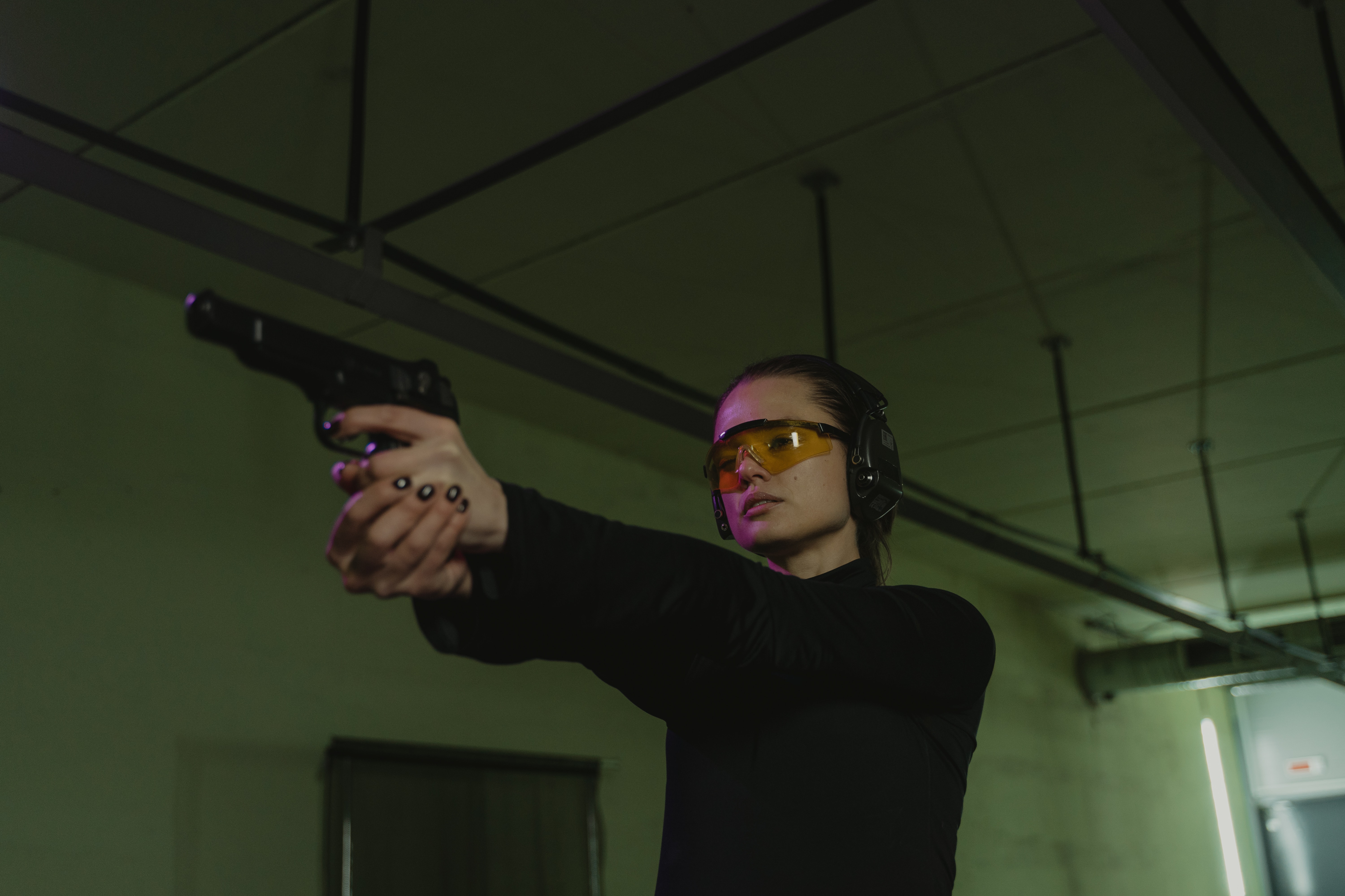 A woman aiming a pistol