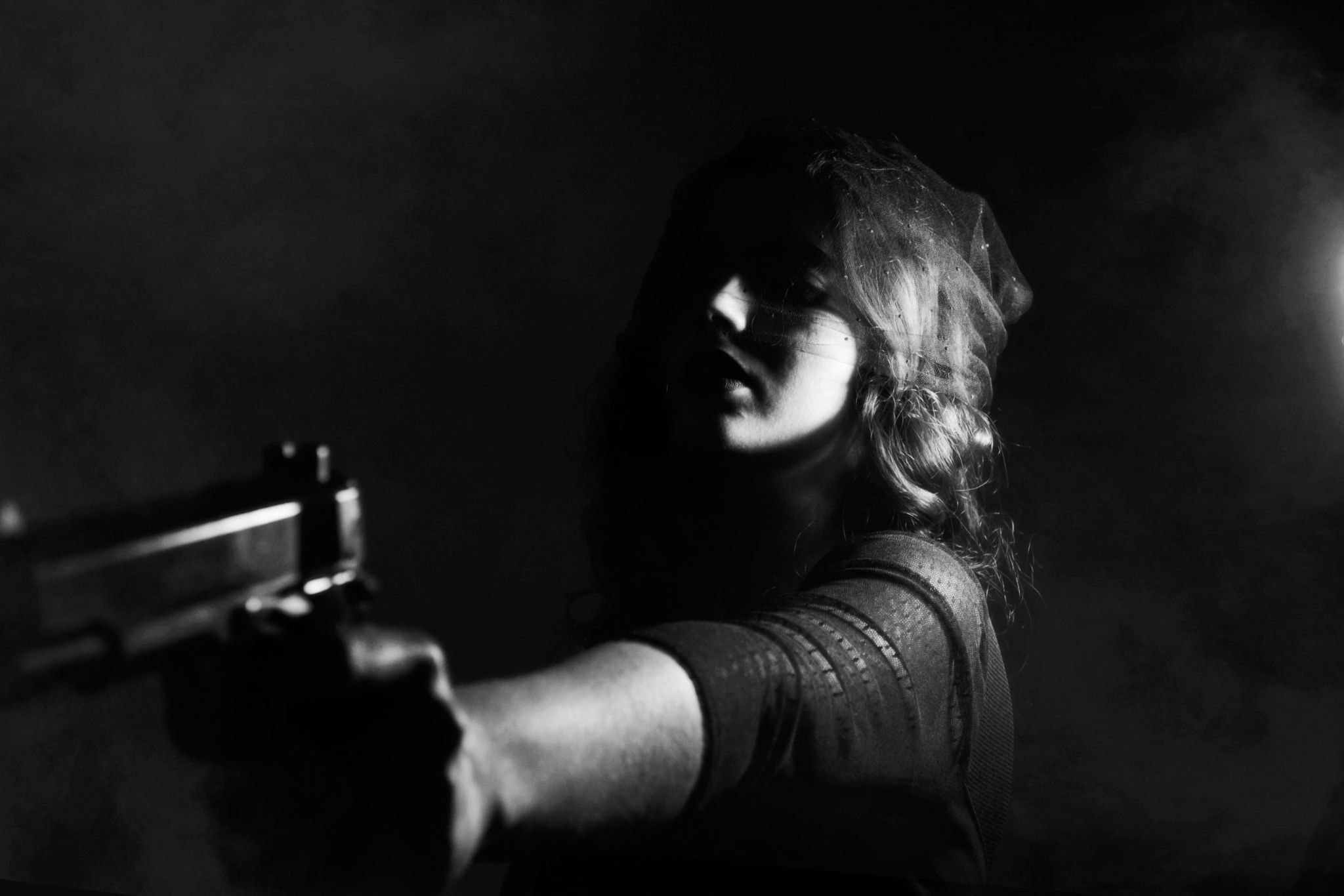Black and white photo of a woman pointing a handgun